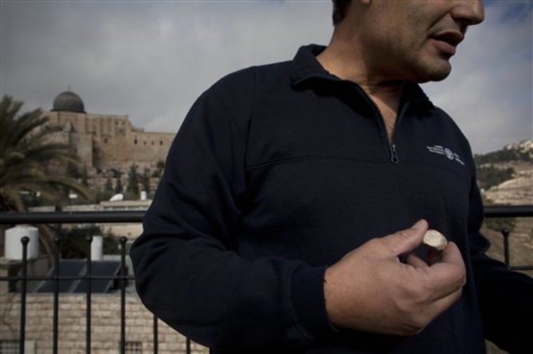 A rare clay seal is displayed during a news conference at the archaeological site known as the City of David in east Jerusalem, Sunday, Dec. 25, 2011. Israeli archaeologists say they have unearthed a rare clay seal that appears to be linked to religious rituals that took place at the Jewish Temple 2,000 years ago. (AP Photo/Oded Balilty)